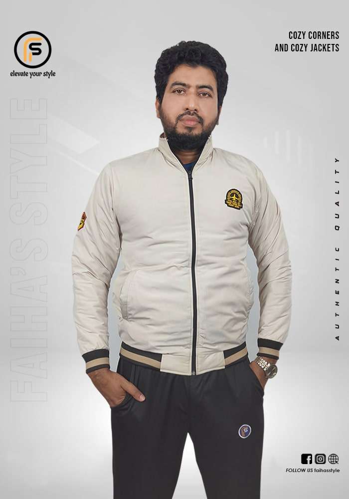 Man modeling a Light Ash beige bomber jacket with a subtle logo on the upper left sleeve. The jacket has ribbed cuffs and hem, adding a snug fit to the classic design. Text overlays read 'Cozy Corners and Cozy Jackets' and 'Authentic Quality,' with 'Faiha's Style' branding in the background